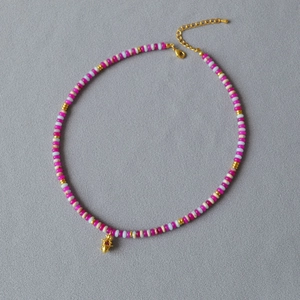 Détail macro du collier de perles dopamine avec perles rose framboise et pendentif