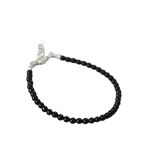 Minimalist black beaded bracelet featuring a unique irregular silver metal toggle clasp