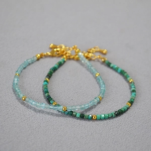 Macro detail of natural aquamarine and turquoise stone bead bracelets with gold clasps