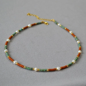 Detail of beaded necklace with freshwater pearls and turquoise stones in boho style