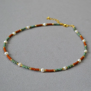 Detail of bohemian pearl necklace with turquoise beads and gold extension chain