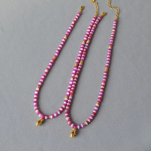 Collier de perles fuchsia avec pendentif étoile dorée et fermoir mousqueton été