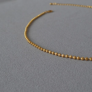 Elegant gold plated brass bead chain necklace with polished finish on a dark background