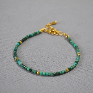 Detailed close-up of faceted green phoenix stone beads with golden spacers and extension chain