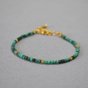 Minimalist turquoise block and gold bead bracelet with adjustable chain on textured fabric