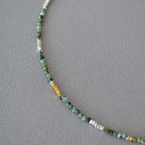 Detailed view of turquoise beads and golden geometric spacers in a handmade necklace