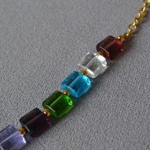 Macro detail of vibrant transparent cube beads with gold metal spacers on chic necklace