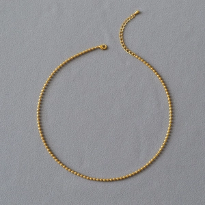 Detail of gold bead chain necklace with lobster clasp and adjustable extension link