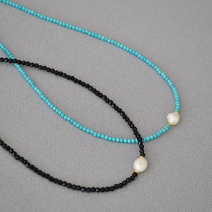 Macro detail of turquoise and black spinel beaded necklaces with baroque freshwater pearls