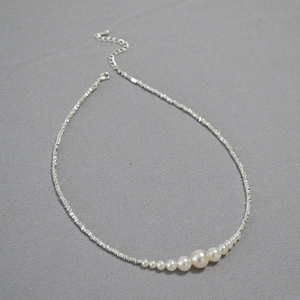 Minimalist irregular silver pearl necklace with gradient white pearls on a silver chain