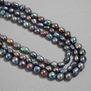 Close-up of triple-layered irregular Baroque pearl necklace with vibrant metallic luster