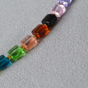Detailed close-up of rainbow bead necklace with rectangular crystals and gold spacer beads