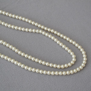 Vue détaillée de perles rondes brillantes sur une surface en tissu gris texturé