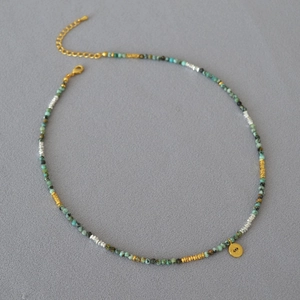 Turquoise beaded necklace with gold Evil Eye pendant and mixed silver accents