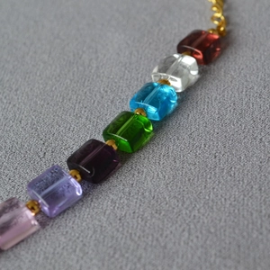 Macro shot of colorful transparent square beads and gold spacers on a chic necklace