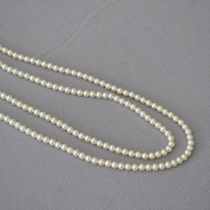 Gros plan détaillé de perles blanches rondes et brillantes sur un collier élégant