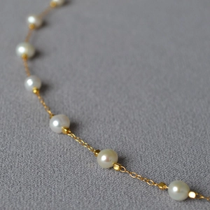 Elegant gold plated brass necklace featuring natural white freshwater baroque pearls