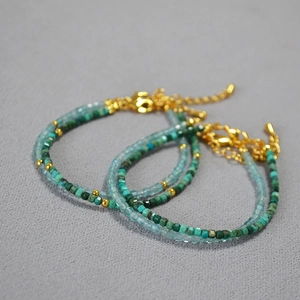 Macro detail of minimalist bead bracelets with blue natural stones and gold accents