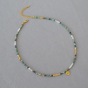 Detailed view of turquoise beads and gold evil eye pendant necklace with lobster clasp
