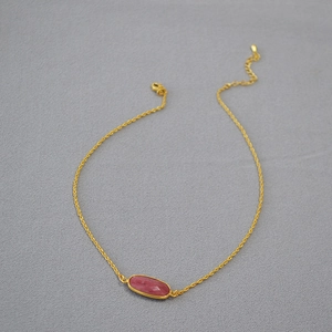 Gold rope chain necklace with a faceted oval pink gemstone and adjustable lobster clasp