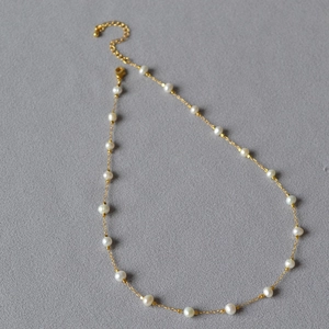 Detail view of irregular baroque pearls on gold-plated brass chain with lobster clasp
