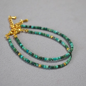 Detail of square turquoise stone beads with gold spacers and adjustable lobster clasp