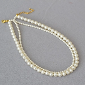 Detail of elegant double-layered pearl necklace with high-gloss beads and golden clasp