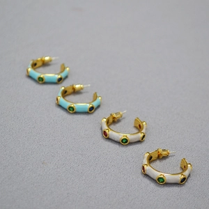 Detailed view of C-shaped 925 silver needle earrings with blue enamel and colorful zircons