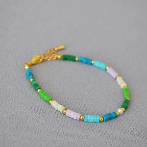 Dettaglio di una collana bohémien fatta a mano con perline quadrate colorate e perla bianca