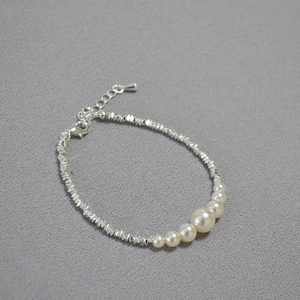 Detail of gradient pearls and faceted silver beads on an adjustable necklace chain