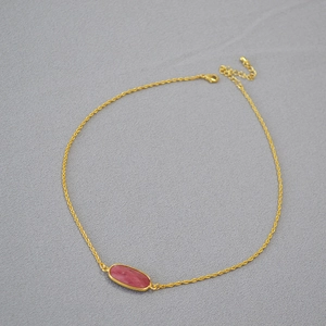 Detail of gold twisted chain with oval pink stone pendant and adjustable clasp