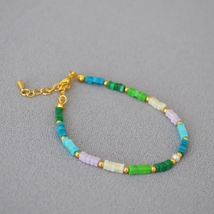 Dettaglio della collana con perline di turchese colorate, chiusura dorata e perla