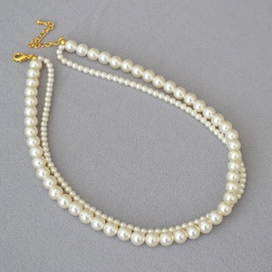 Detail of double-layer faux pearl necklace with gold-tone lobster clasp and extender chain