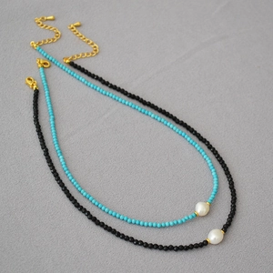 Detail of beaded necklaces featuring black spinel, turquoise, and baroque pearls