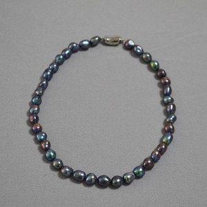 Macro detail of irregular baroque pearls with peacock green and purple metallic luster