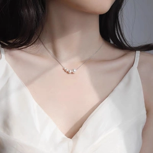 Collier minimaliste plaqué or avec quatre perles dégradées sur une chaîne fine