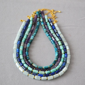 Detail of natural stone cylinder bead necklaces with gold spacer beads and lobster clasp