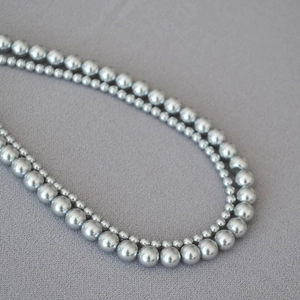 Detail of elegant double-layered gray faux pearl necklace with metallic luster finish