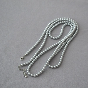 Détail du collier de perles grises avec fermoir mousqueton argenté et chaîne réglable