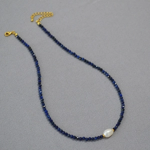 Detail of beaded necklace with black spinel, turquoise, and a baroque pearl focal bead