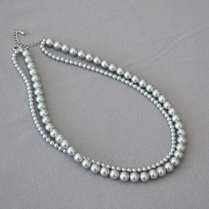 Detail view of double-layer faux pearl necklace with silver-tone lobster clasp