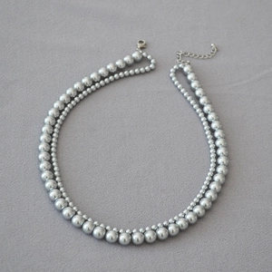 Close-up of double-layered faux pearl necklace with silver-tone lobster clasp and chain