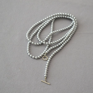 Détail d'un collier en perles gris argenté avec fermoir à bascule T-bar de style minimaliste
