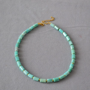 Detail of light blue cylindrical Amazonite stone necklace with golden spacer beads