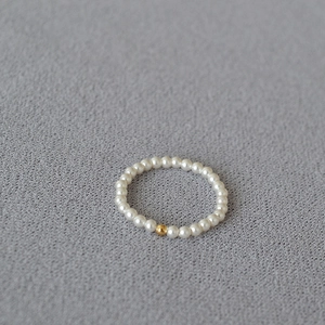 Macro detail of delicate 14K gold filled bead and translucent pearl beaded ring