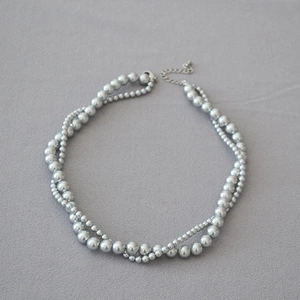 Close-up of double-layer silver-grey faux pearl necklace with lobster clasp and chain