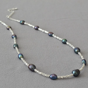 Close-up of irregular Tahitian pearls and shiny silver beads on a choker necklace