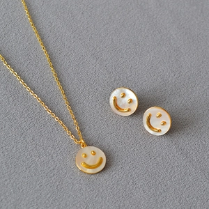Set collana e orecchini placcati in oro con faccina sorridente e madreperla bianca