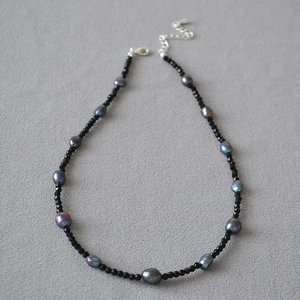 Dettaglio macro di perle di spinello nero e perle barocche con chiusura regolabile