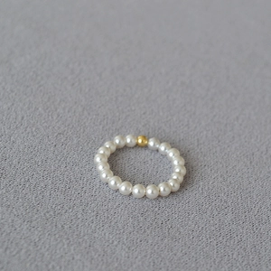 Macro shot of minimalist 14K gold-filled bead and delicate faux pearl beaded ring